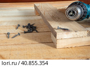 Self-tapping screws and a drill-screwdriver on wooden boards. Home life, DIY. Стоковое фото, фотограф Александр Кротков / Фотобанк Лори