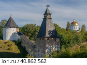 View of the outer wall of the Holy Dormition Pskov-Pechersk Monastery, the Tower of the Upper Lattices, the Khvostovsky Tower and St. Michael's Cathedral on a sunny summer day, Pechory, Pskov region, Russia. Стоковое фото, фотограф Ula Ulachka / Фотобанк Лори