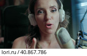 A beautiful brunette woman blogs and broadcasts live from her home video studio. Стоковое видео, видеограф Анатолий Типляшин / Фотобанк Лори