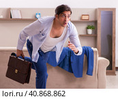 Young male employee getting up late at home. Стоковое фото, фотограф Elnur / Фотобанк Лори