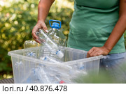 Container of plastic bottles. Garbage collection around the world. Clean the planet of plastic garbage. Ecology. A woman sorts garbage. Стоковое фото, фотограф Photojuli / Фотобанк Лори
