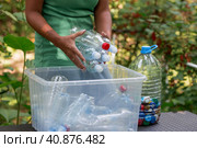 Container of plastic bottles. Garbage collection around the world. Clean the planet of plastic garbage. Ecology. A woman sorts garbage. Стоковое фото, фотограф Photojuli / Фотобанк Лори