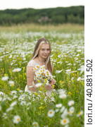 Beautiful romantic teen girl, young woman with a bouquet of wildflowers in the field on a sunny summer day. Child with disabilities. Equal opportunities for all. Стоковое фото, фотограф Ирина Михайличенко / Фотобанк Лори