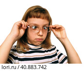 Cute 7 year old Caucasian girl looks into glasses. Eyes in a bunch. Ophthalmic problems in children. Myopia, exophoria and astigmatism. Selection of glasses. Isolate white background. Back to school. Стоковое фото, фотограф Юлия Петровская / Фотобанк Лори
