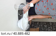 A woman is unpacking an online purchase. Dishes for cats. Bowls for water and food, automatic drinker. vertical video. Стоковое видео, видеограф Vadzim Yakubovich / Фотобанк Лори