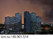 Многоэтажные современные жилые дома на закате перед дождем. Москва. Россия (2023 год). Редакционное фото, фотограф E. O. / Фотобанк Лори