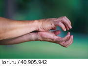 Photography of two tense female and male hands grabbing each other. They are catching or showing something . Natural green background. Close up image. Стоковое фото, фотограф YuryKara / Фотобанк Лори