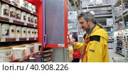 Buyer selects paint and plaster in the store (2018 год). Редакционное фото, фотограф Анна Кривицкая / Фотобанк Лори