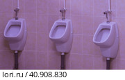 Photography of a line of urinals in the men's restroom. Modern lifestyle of big city. Public WC. Стоковое фото, фотограф YuryKara / Фотобанк Лори