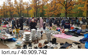 Flea market with goods laid out on the ground and customers (2019 год). Редакционное фото, фотограф Анна Кривицкая / Фотобанк Лори