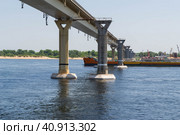 Волгоград, река Волга, Россия. Движение грузового судна, танкера, газовоза, под мостом на Волге. Транспортировка нефти и сжиженного природного газа по реке. (2022 год). Редакционное фото, фотограф Андрей Цыганков / Фотобанк Лори