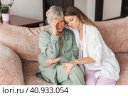 Grown up daughter soothe aged mother holds her hand feel empathy give her moral support, sad elderly woman at home. Стоковое фото, фотограф Гладских Татьяна / Фотобанк Лори