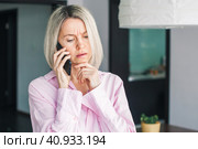 middle-aged woman holding phone, reading unpleasant news in social media. Стоковое фото, фотограф Гладских Татьяна / Фотобанк Лори