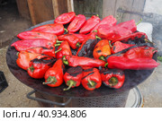 Roasting red peppers for a smoky flavor and quick peeling. Thermal processing of the pepper crop on a metal circle. Brazier container used to burn charcoal fuel for cooking, heating or cultural ritual. Стоковое фото, фотограф Юлия Петровская / Фотобанк Лори
