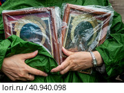 Православная верующая держит копию иконы Всемилостивого Спаса во время крестного хода в храмовый праздник Воскресенского собора в городе Тутаев, Россия (2023 год). Редакционное фото, фотограф Николай Винокуров / Фотобанк Лори