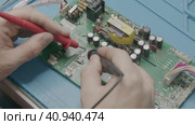 The wizard uses an electronic tester to test the components on the computer board. Стоковое видео, видеограф Aleksey Kidisyuk / Фотобанк Лори