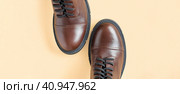 Brown shoes. Trendy Boots Pair on Neutral Beige Background. Copy space, top view, flat lay. Shoe sale, fashion concept. Stylish Casual shoes for city. Overhead shot of chelsea boots. Urban lifestyle. Стоковое фото, фотограф Марина Демидюк / Фотобанк Лори