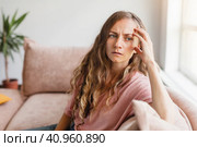 Sad woman thinking about problem, sitting alone on couch. Стоковое фото, фотограф Гладских Татьяна / Фотобанк Лори