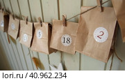 Christmas Advent Calendar. Paper bags, dry fruits, string on white table. Seasonal activity for kids, family winter holidays. Handmade tinkered calendar, natural material. DIY. Soft Focus. Top View. Стоковое видео, видеограф Марина Демидюк / Фотобанк Лори