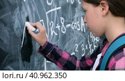 Sad pupil trying to solve an example. Schoolgirl stands with her forehead on the blackboard. Teenage girl solving advanced mathematical problems and banging his head on chalkboard. This is too hard. Стоковое видео, видеограф Марина Демидюк / Фотобанк Лори