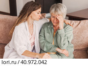 Grown up daughter soothe aged mother holds her hand feel empathy give her moral support, sad elderly woman at home. Стоковое фото, фотограф Гладских Татьяна / Фотобанк Лори