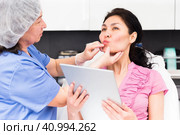 Cosmetologist consulting woman before procedures for lip augmentation. Стоковое фото, фотограф Яков Филимонов / Фотобанк Лори