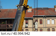 Sremska Mitrovica, Serbia 08.09.23 Hoisting crane, machines designed for movement of goods, the temporary engagement of which is carried out using lifting devices hook hangers. Multistory building (2017 год). Редакционное видео, видеограф Юлия Петровская / Фотобанк Лори