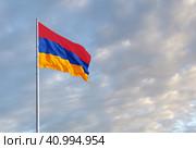 Waving Armenian flag against a blue sky with clouds and empty space for text. Room for text. Стоковое фото, фотограф Алексей Игнатов / Фотобанк Лори
