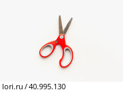 Канцелярские ножницы на белом фоне. Ножницы с красной ручкой. Stationery scissors on a white background. Scissors with a red handle. Стоковое фото, фотограф Ольга Митряева / Фотобанк Лори