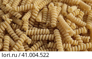 Gluten Free Cornmeal Pasta Wallpaper. Spiral Raw Macaroni from Corn and Rice flour rotating on Turntable. Close Up Top View. Uncooked Pasta Spinning. Full Frame. Food Background. Fusilli Bucati Corti. Стоковое видео, видеограф Марина Демидюк / Фотобанк Лори