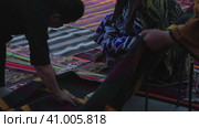 Tashent, Uzbekistan - 4 11 2022: the hand of a weaver weaving a handmade carpet. Редакционное видео, видеограф Aleksey Kidisyuk / Фотобанк Лори