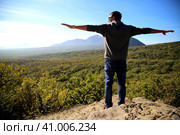 A young man stands at the top of a mountain. Стоковое фото, фотограф Egor Sarantstv / Фотобанк Лори