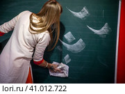 Преподаватель учит людей писать буквы на доске древнего восточного языка санскрита (2023 год). Редакционное фото, фотограф Николай Винокуров / Фотобанк Лори
