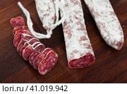 Slicing delicious Spanish smoked sausage fuete. Стоковое фото, фотограф Яков Филимонов / Фотобанк Лори