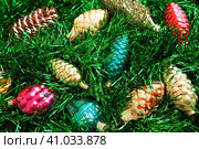 Multi-colored glass cones on green Christmas tree tinsel. Beautiful Christmas toys and decorations as a background. Red, yellow, green and pink shiny new year and christmas figurines. Стоковое фото, фотограф Юлия Петровская / Фотобанк Лори