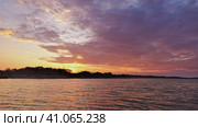 A flaming sunset over the Zambezi River. Clouds of purple and scarlet hues. The horizon is highlighted in gold. Reflections on the surface of the water. Zimbabwe. Стоковое фото, фотограф Вера Ивановна Кубарева / Фотобанк Лори