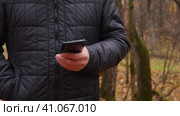 Руки пожилого человека, использующего мобильный телефон в осеннем парке. Стоковое видео, видеограф Евгений Ковальский / Фотобанк Лори
