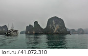 The fog hides islands with bizarre outlines and steep slopes. A tourist ship is sailing on calm water. Halong Bay. Vietnam. Стоковое фото, фотограф Вера Ивановна Кубарева / Фотобанк Лори