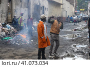 A man poses on the dirty streets in downtown Nairobi. Kenya, Africa (2022 год). Редакционное фото, фотограф Алексей Кузнецов / Фотобанк Лори