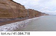 Крутой высокий скалистый берег северного моря. Живописный вид на море с водопадом на горе. Красивая природа острова Сахалин в России. Стоковое видео, видеограф Денисова Виктория / Фотобанк Лори