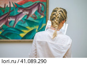 HAMBURG, GERMANY - 9 JULY 2017: Hamburg Kunsthalle art museum. Jung woman read exhibition information about painting. Стоковое фото, фотограф Igor Tichonow / Фотобанк Лори