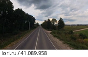 The drone's camera is flying over the road at high speed in the countryside. Summer trip. Стоковое видео, видеограф Ярославский Максим / Фотобанк Лори