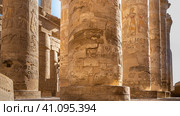 Colonnade in the ancient Egyptian Karnak Temple of Luxor. Close-up. Hieroglyphs and carvings are visible on the columns. Blue sky. (2021 год). Стоковое фото, фотограф Вера Ивановна Кубарева / Фотобанк Лори