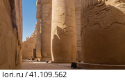 Hypostyle hall of the Karnak Temple in Luxor. Rows of ancient columns and dilapidated walls against the blue sky. Hieroglyphs and carvings are visible. Close-up. Egypt (2021 год). Стоковое фото, фотограф Вера Ивановна Кубарева / Фотобанк Лори