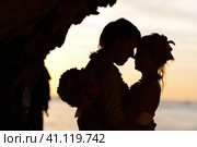 Силуэт обнявшихся юноши и девушки в лучах заходящего солнца. Пещера, океан, небо. Стоковое фото, фотограф Сергей Никифоров-Гордеев / Фотобанк Лори