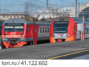 Два пригородных электропоезда на Балтийском вокзале солнечным летним днем. Санкт-Петербург (2023 год). Редакционное фото, фотограф Виктор Карасев / Фотобанк Лори