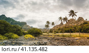 Panorama of dried-up stream surrounded by fertile green valley and rugged cliffs. Santo Antao, Cabo Verde. Стоковое фото, фотограф Igor Tichonow / Фотобанк Лори