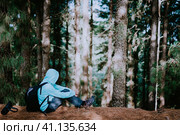Traveler take a rest during hike in mysterious pine tree forest and endjoyed the silence. Santo Antao Island, Cape Verde. Стоковое фото, фотограф Igor Tichonow / Фотобанк Лори