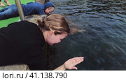Люди играют с медузами вдоль пирса уходящего в Чёрное море. People play with jellyfish along the pier stretching into the Black Sea. Стоковое видео, видеограф Станислав Типляшин / Фотобанк Лори