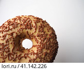 A doughnut or donut. A type of leavened fried dough. Sweet snack that can be homemade or purchased in bakeries, supermarkets, food stalls. Delicious pie with light icing on a white background. Стоковое фото, фотограф Юлия Петровская / Фотобанк Лори